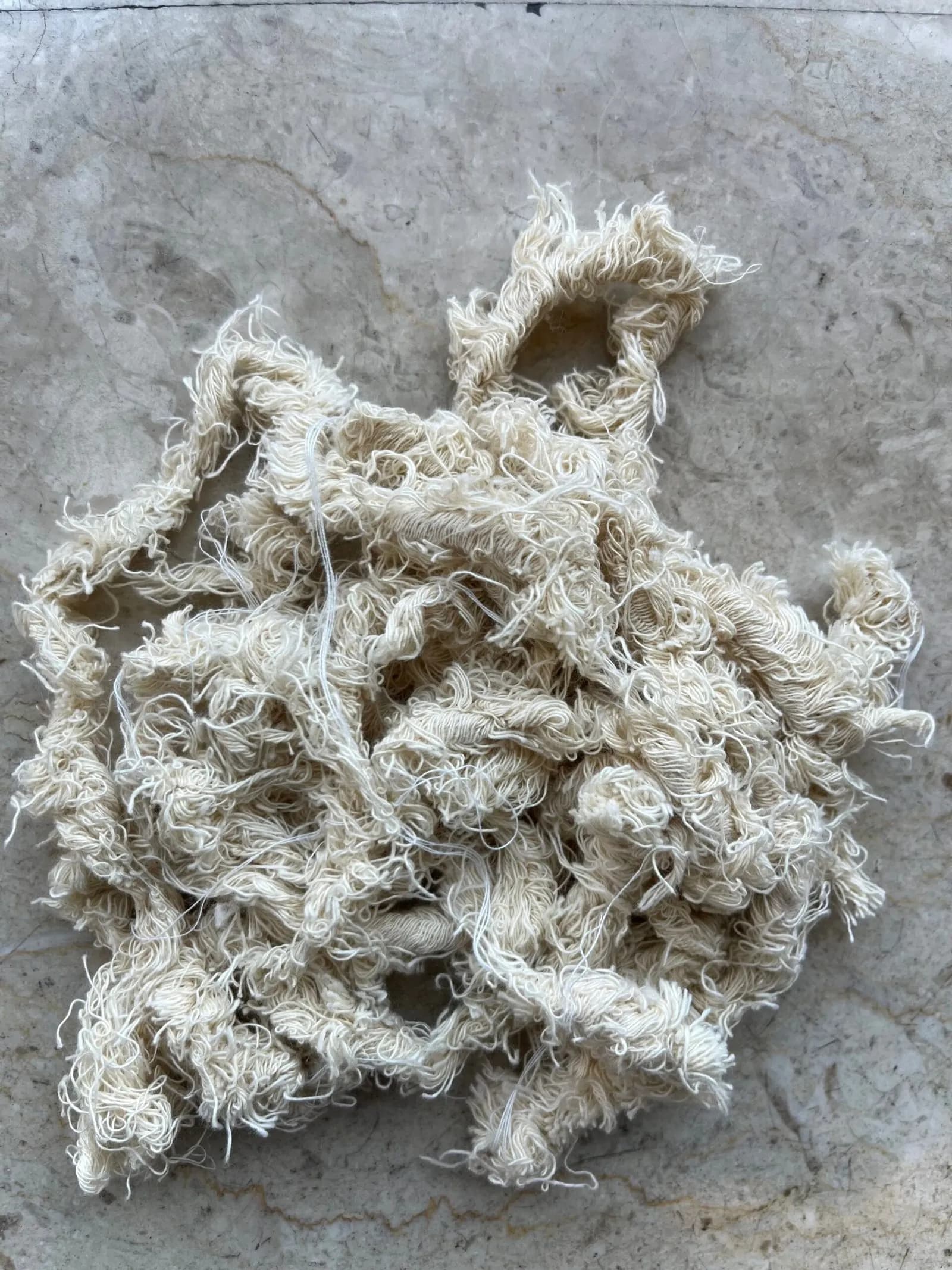 Cotton selvedge waste on a stone floor